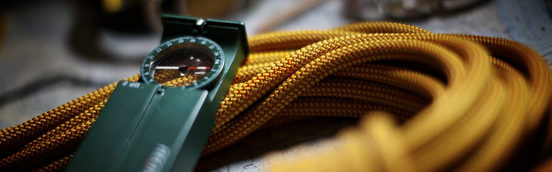 ein Kompass sitzt auf einem Seil mit einer gelben Schnur 